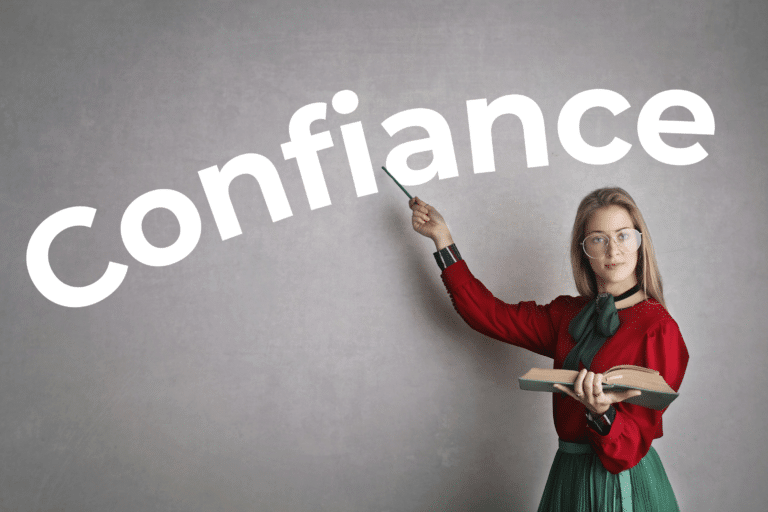 Une enseignante se tient devant un tableau noir sur lequel est écrit "Confiance"